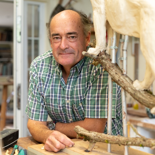 Sculptor Mark Coreth poses with one of his sculptures for the video