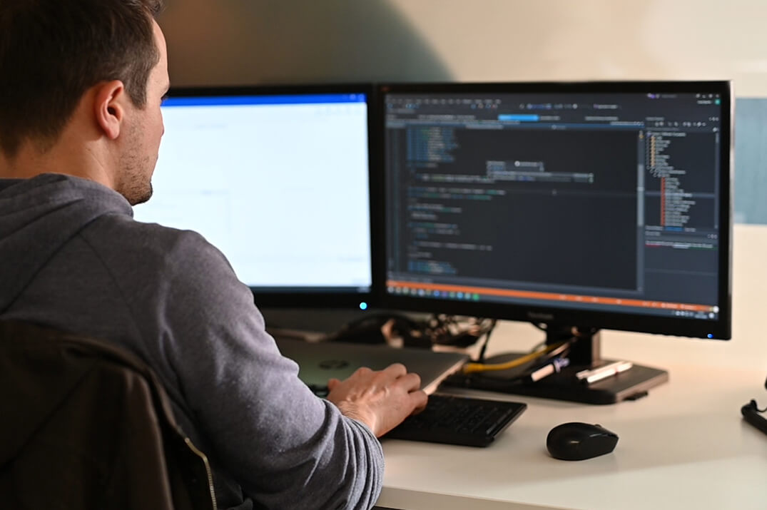 Technician working at a desk with log files on his screen