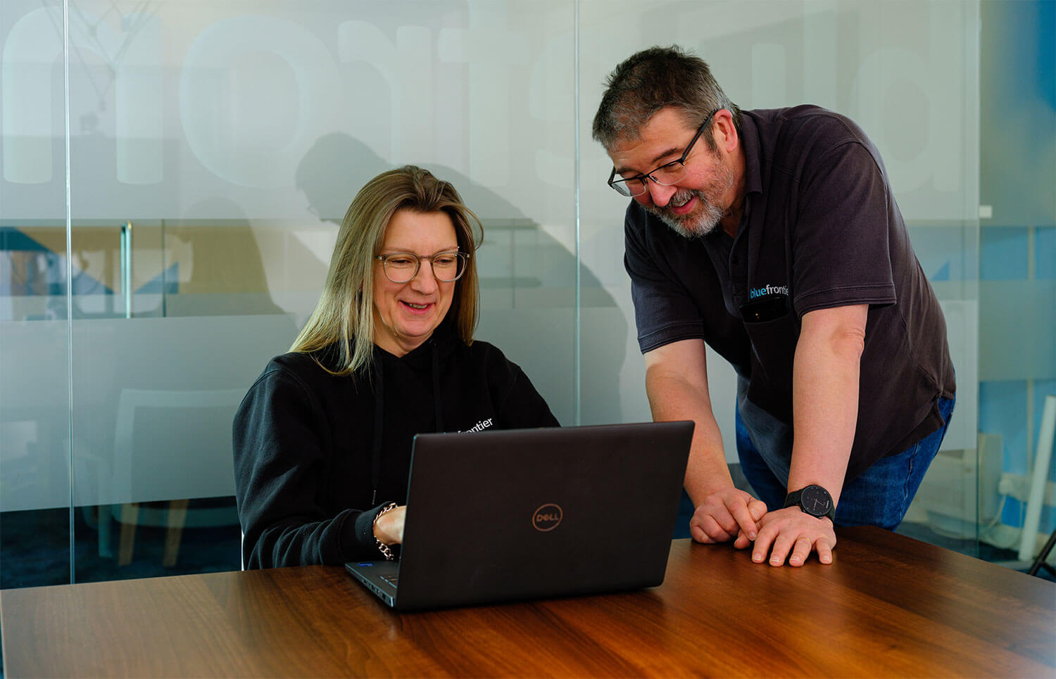 Two happy people looking at a laptop