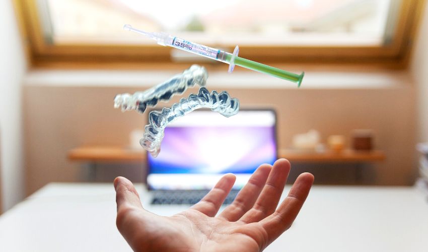 A photo of a dentist reaching out to a set of retainers and syringe, exploring the virtual world