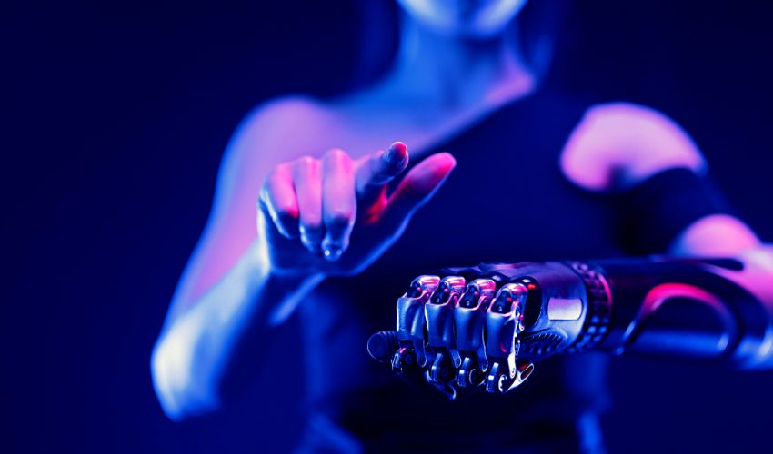 A photo of a woman using a specially-created bionic arm whilst wearing a virtual reality headset