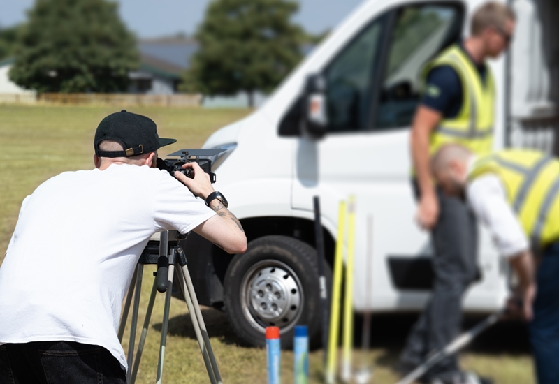 A videographer looks down their camera lens during a shoot